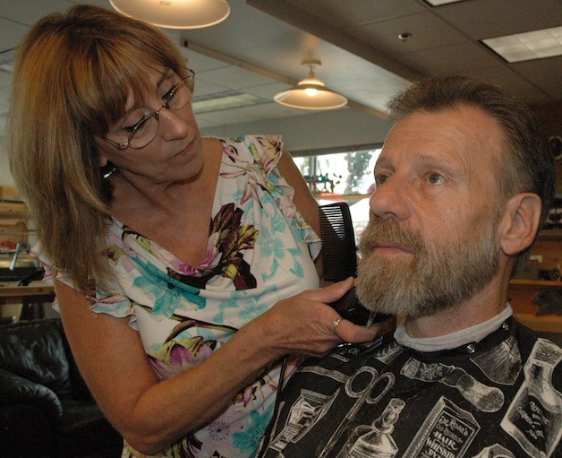 Hairport barber Debby Chism applies the finishing touches on Butch Laird's trim.