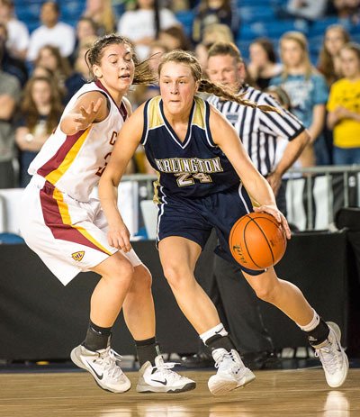Arlington's Jessica Ludwig moves the ball up court against a Moses Lake defender during the first round of the 4A State Tournament in Tacoma on March 6.