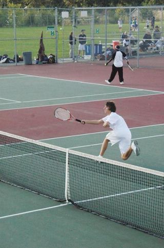 Will Heath stretches out to reach a forehand at the net during his doubles teams straight set victory over Lake Stevens.