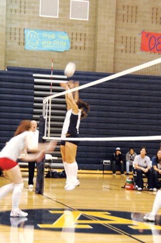 Twin towers Kjirsten Jensen and Breanna Covey leap to block a Stanwood spike attempt.