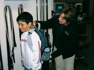 Andrew Kalahar receives a backpack fitting from physical therapist Elaine Andersen at Cascade Rehabilitation Associates in Smokey Point.