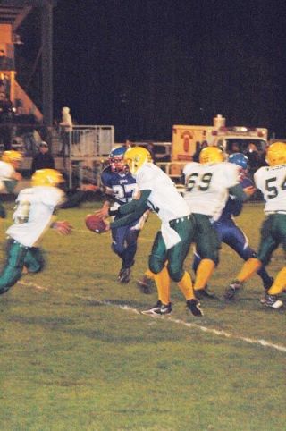 Quarterback Mark Jones hands the ball off for the Darrington Loggers. The Loggers went into a hostile environment and emerged with a 28-0 victory over LaConner.
