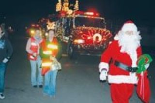 Vanessa Carbajal and Andi Carbajal help Santa Claus distribute candy canes to kids and families at Airway Mobile Park Saturday
