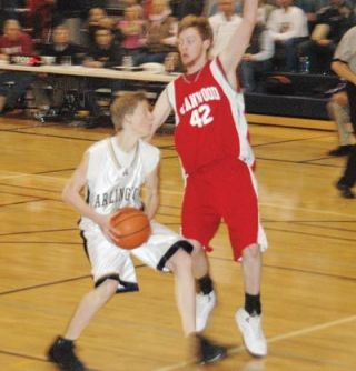 Lucas Larson challenges Stanwoods big man on a drive during Arlingtons 53-48 loss to the Spartans.