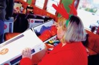 Gen Fromong gets into the holiday spirit as she places calendars into care packages for military