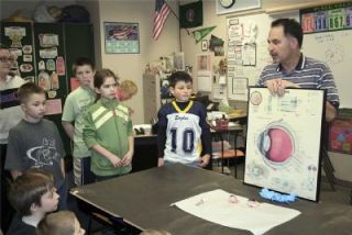 Dr. Kim Kron uses a chart to compare the parts of the eye to those of a camera.