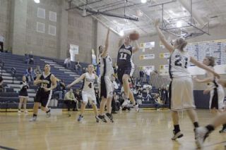 Squalicums Calial Lyon throws up a hand as Arlingtons Christina White drives to the basket.