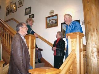 Dan Grewe and Arnold Garka visit on the handcrafted wooden staircase of the Stillaguamish Valley Pioneer Museums anniversary Party March 10.