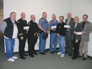 The Stillaguamish Tribe of Indians checks draw smiles from representatives of the Snohomish County Sheriffs Office