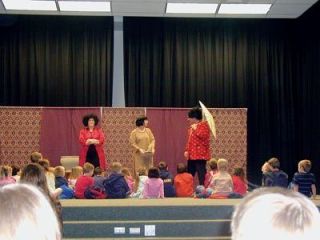 Children gather up close to a stage performance
