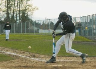 Caleb Scarth extends the bat to reach a low fastball during the April 11 contest between Arlington and Stanwood
