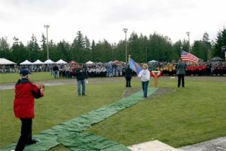 Arlington Mayor Margaret Larson throws out the first pitch on the newly rededicated Quake Field.