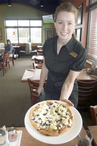Boston Pizza Manager Jennifer Haffner shows off one of the custom-ordered gourmet pizzas available at the Smokey Point restaurant.