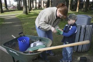 Arlington mom Gretchen Reed helps her son Cade don his work gloves.