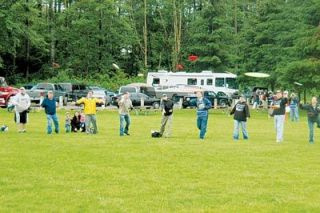 Arlington residents marked opening day at the Arlington Disc Golf Course June 16 by encircling a central disc golf basket and tossing their discs all at once. The ceremony is known at the ring of fire.