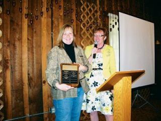 Connie Foster accepts the Arlington Garden Clubs annual Myrtle Ruckert Award at the clubs dessert luncheon at Pioneer Hall Saturday
