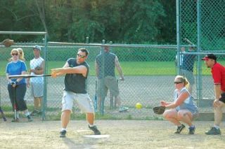 Matt Allison takes a mighty hack at this pitch for Team Busted and Bruised on the opening night of Arlingtons rec league softball.