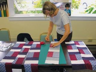 Wilma Hamm sews quilt strips together.