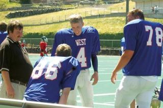 Arlingtons Trevor Milless talks to standout Edmonds-Woodway receiver Eric Greenwood on the sidelines during the East-West football game June 30. Milless West team came from behind with 15 unanswered points in the second half to defeat the East.