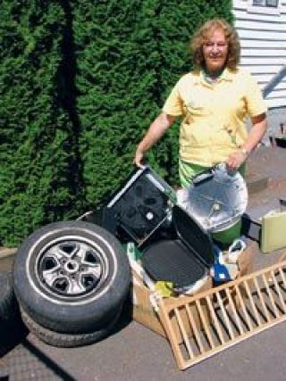Helping Hands Vice President Lana Lassley shows some of the many broken and otherwise unusable items that are dumped outside the groups building on a daily basis.