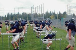 Arlington football players go through a series of leg exercises during the tough two-a-day practices that will prepare them for the season.