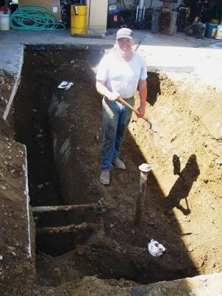 Jim Howell removes an old oil tank from the ground under his repair shop that was formerly a gas station. Howell has been waiting for two weeks to get the dirt inspected before refilling the hole.