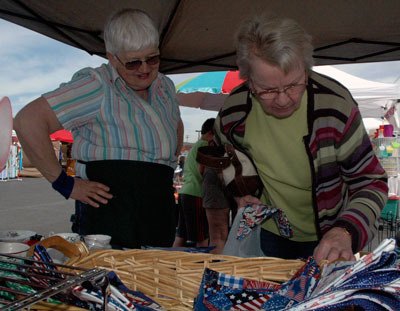 May Hunt vendor Judy Smith looks on as first-time May Hunt customer Doris Keezer checks out her handmade wares on May 11.