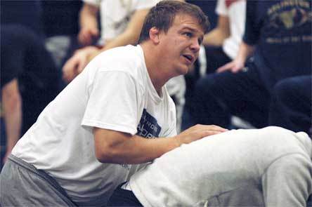 Arlington coach Shaun Williams demonstrates a containment move on senior David Lopez-Nava during practice.