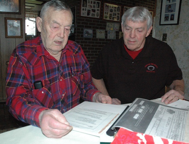 Elwood Barker and his son Steve pore over his old memory books