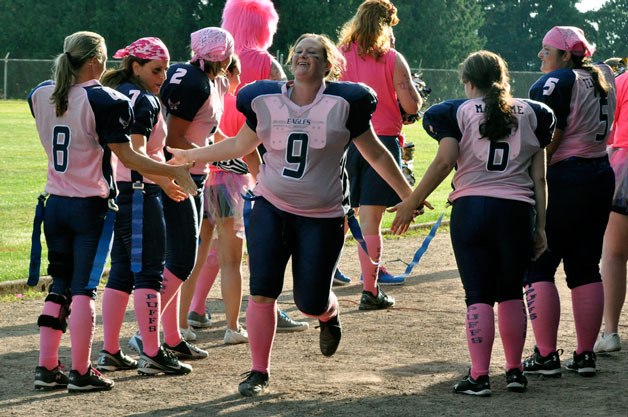 Nikki “Skelley” Roskelley high-fives teammates and cheerleaders as the Arlington Eagle Moms take the field during the second annual Stilly Puff Cup Powder Puff Football game.