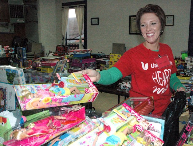 Volunteer Vanessa Pawley of Union Bank picks out some girls’ toys for a client of the Arlington holiday toy store on Dec. 18.