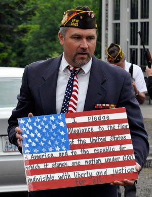 Veteran Robert Dyson holds an American flag sign while leading the Pledge of Allegiance during a Flag Day ceremony on June 14 at the Stillaguamish Valley Pioneer Museum.