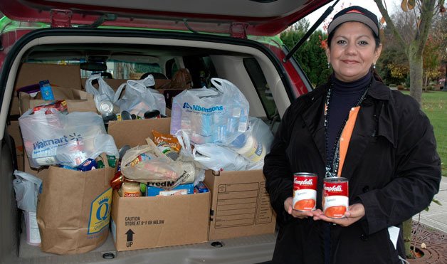 M.J. Drush of Servpro shows off the estimated 300 pounds of food collected at the Olympic Theatre’s Nov. 13 showing of “Megamind.”