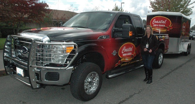 Kent Prairie Elementary fourth-grade teacher Leah Robinson is all smiles as she stands next to the 2013 diesel-fueled Ford F-250 Super Duty pickup truck and two-horse steel trailer that the Oregon-based Coastal Farm & Ranch chain presented to her at her school on Sept. 24.