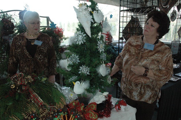 Arlington Garden Club members Kitty Finch and Sandy McDonald assess the decorations at their own vendor table during their Nov. 23 Holiday Garden Art and Crafts Show.