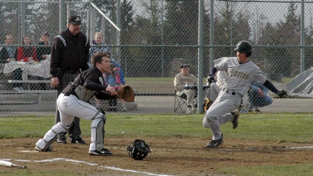 The Lynwood catcher waits for the throw as Arlington High School’s Mario Mirante slides into home on March 22.