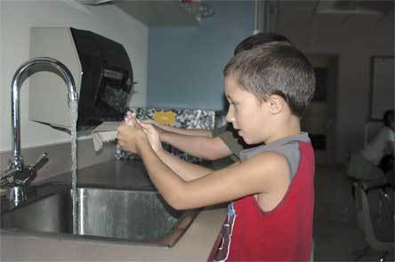 Second-grader Brody Bates washes his hands Sept. 16 during a Cascade Valley Hospital clinic at Eagle Creek Elementary.