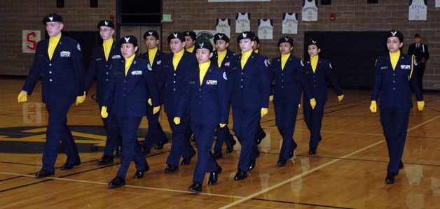 The Arlington Air Force Junior ROTC unarmed drill team steps sharp for inspectors and crowds in the stands of the Arlington High School gym.