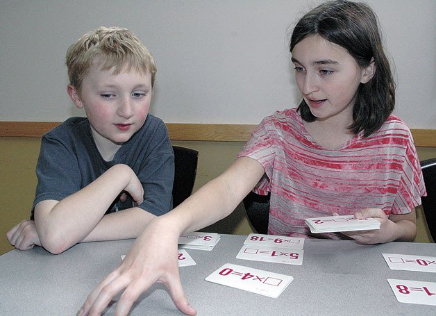 Presidents Elementary fourth-grader Jesse Wellman receives tutoring from former Presidents student Morgan Daigneault