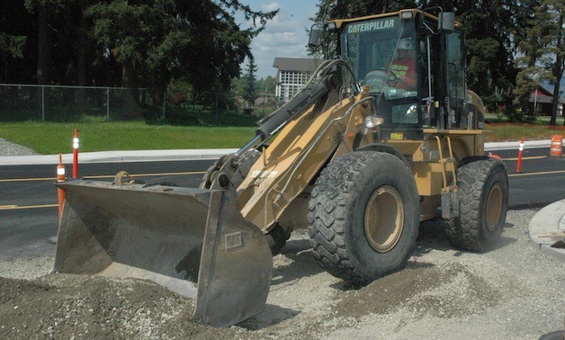 Equipment operator Marshal Rommel evens out the gravel on one of the driveways connecting 67th Avenue to Taylor Industrial Park on May 7.