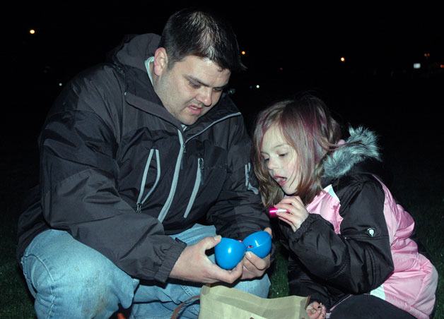 Shorelineâ€™s Danial Wanke elicits awe from daughter Alyssa as he cracks open her plastic prize eggs during the flashlight Easter egg hunt for the Arlington Relay For Life on March 31.