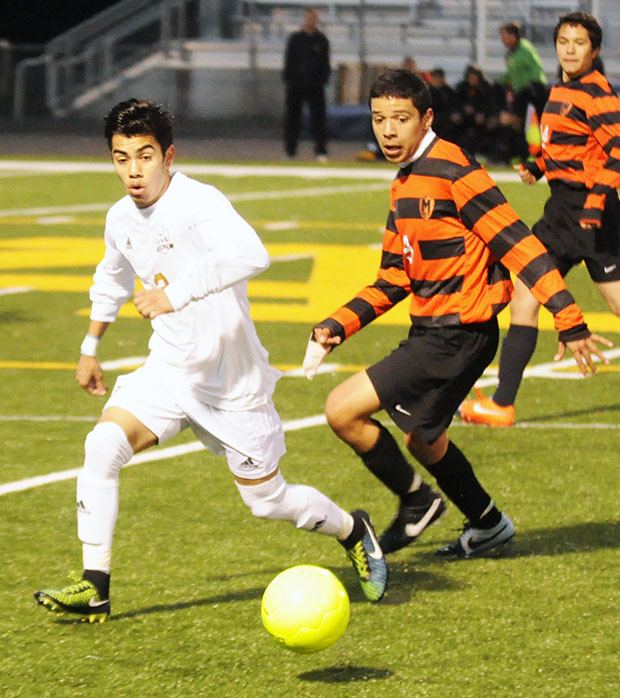 An Arlington soccer player fights for possession against a Monroe player.