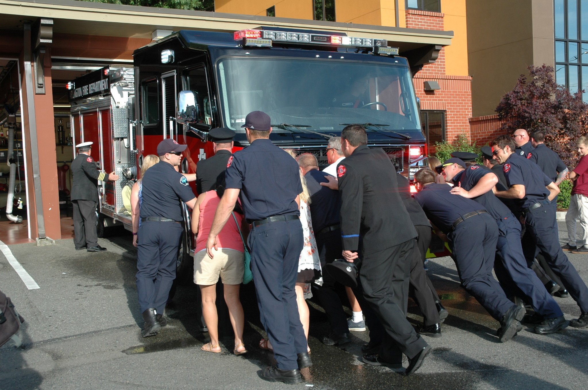 Kirk Boxleitner/Staff PhotoArlington firefighters and citizens help push the city’s new fire engine into its bay at Station 46 June 6.