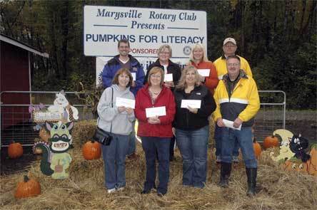 Representatives of the Arlington School District are pleased to receive “Pumpkins for Literacy” funds from the Marysville Rotary at the Smokey Point Plant Farm Oct. 31. From left