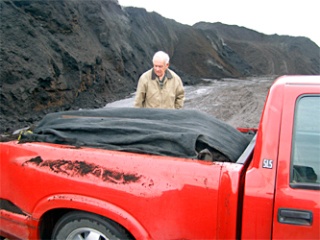 Keith Sarkisian examines a load of compost after he and Jim Davis
