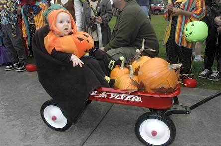 Austin Kaminski is carted around as a “little pumpkin” for Halloween in downtown Arlington.
