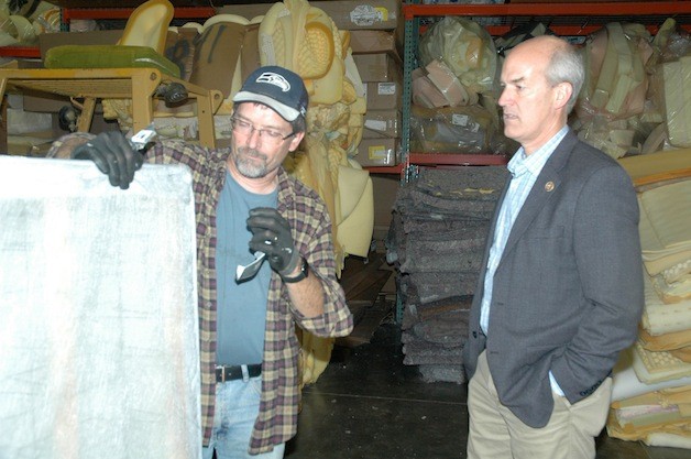 Mike Zachman shows U.S. Rep. Rick Larsen how his workers recycle mattresses.
