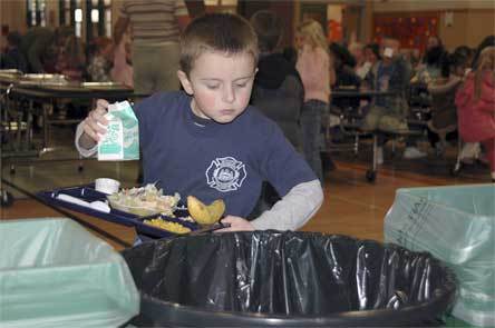 Kindergartner Aiden Green sorts food compost from garbage at Presidents Elementary.