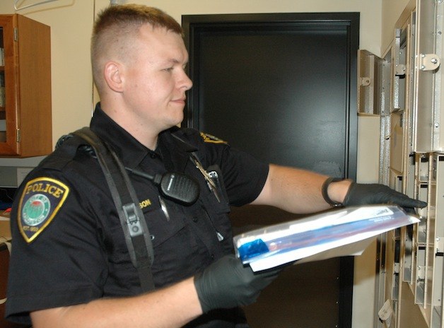 Officer Justin Olson files evidence at the Arlington Police Department.