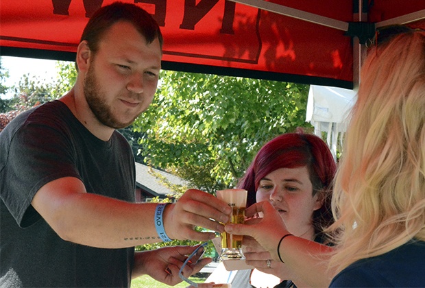 Brandon Adam/Staff PhotoDaniel Johnson is handed a beer sampling at Vision for a Cure’s Brewfest at Legion Park July 23.